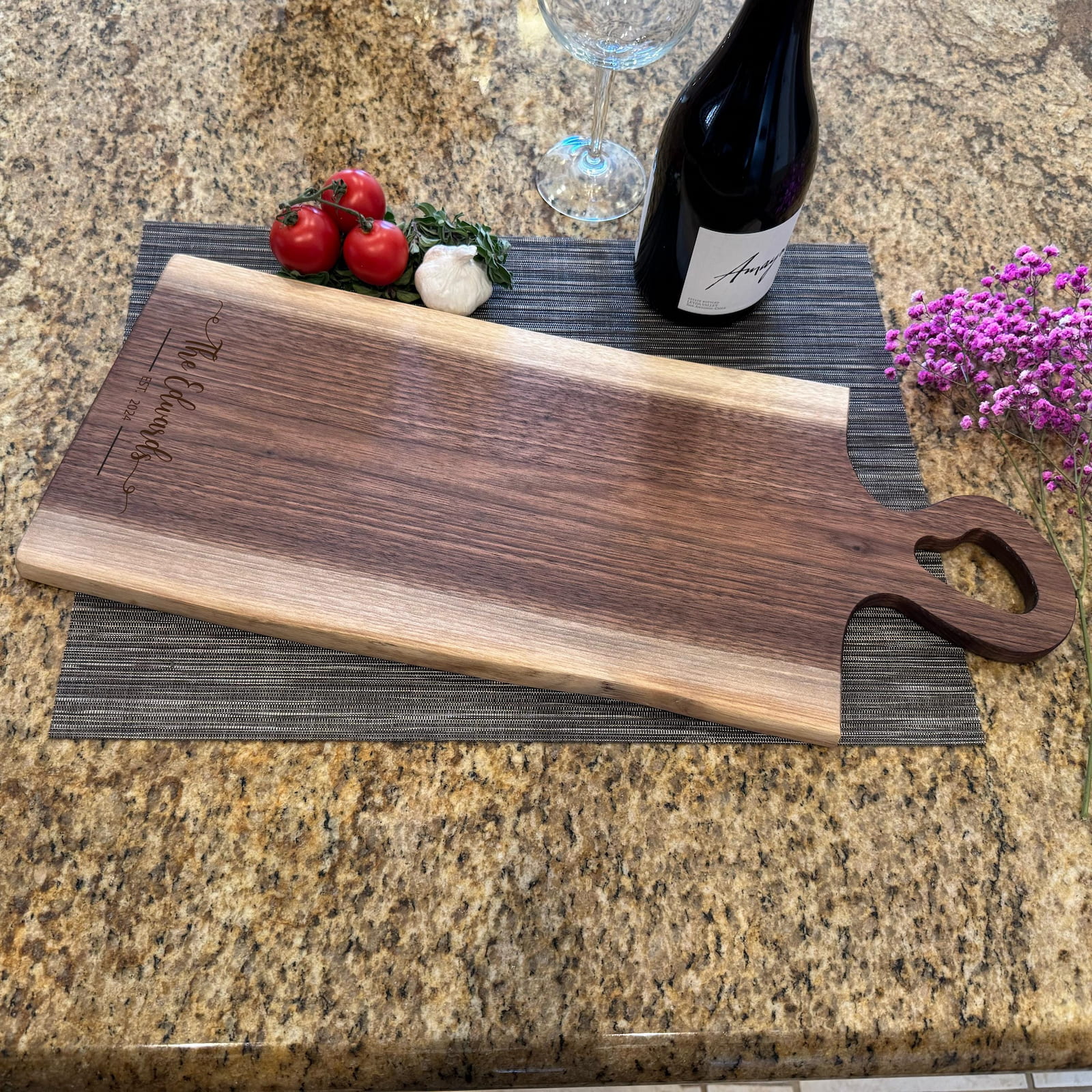 Live edge walnut charcuterie board with heart-shaped handle, wine, and fresh ingredients