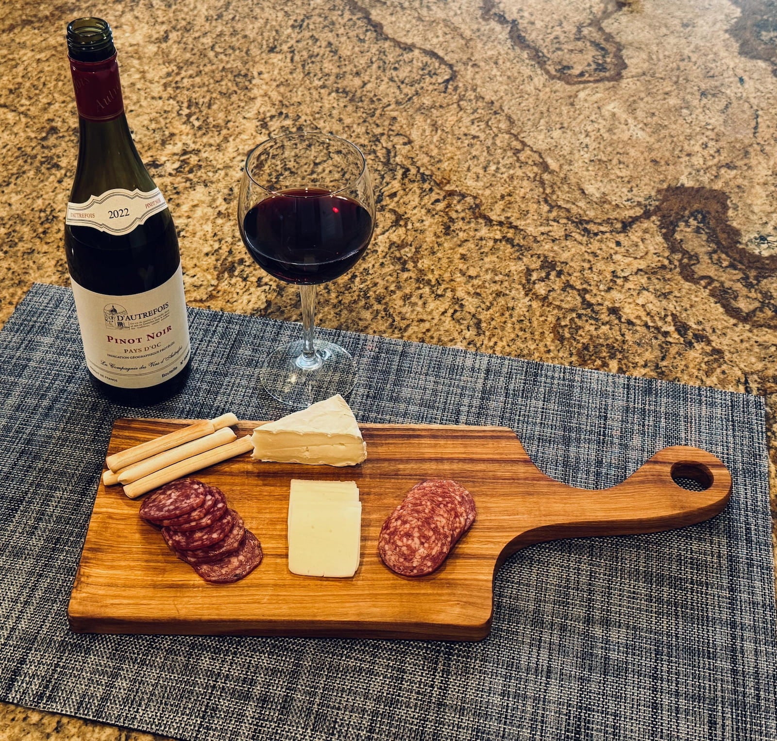 Canary charcuterie board with wine, cheese, and appetizers on kitchen countertop