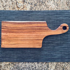 Canary wood charcuterie board with handle on kitchen countertop