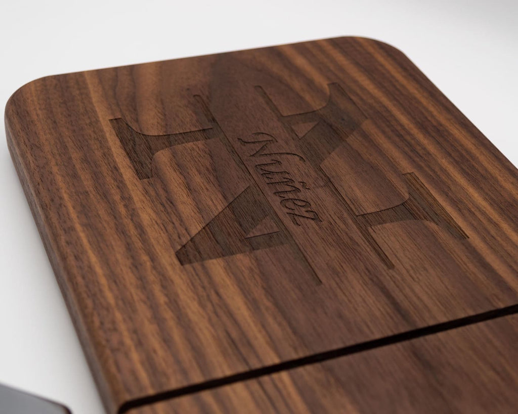 Detailed view of engraved split monogram and family name on handcrafted walnut cheese slicer