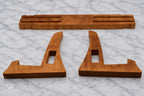 Three-piece hardwood cutting board stand disassembled to show its interlocking construction