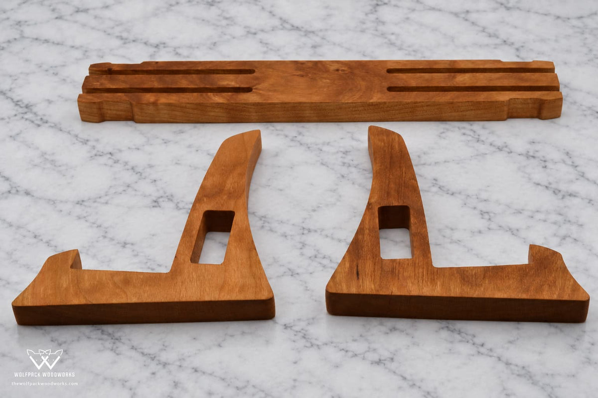Three-piece hardwood cutting board stand disassembled to show its interlocking construction
