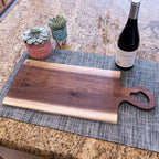 Live edge walnut charcuterie board with heart-shaped handle and wine bottle