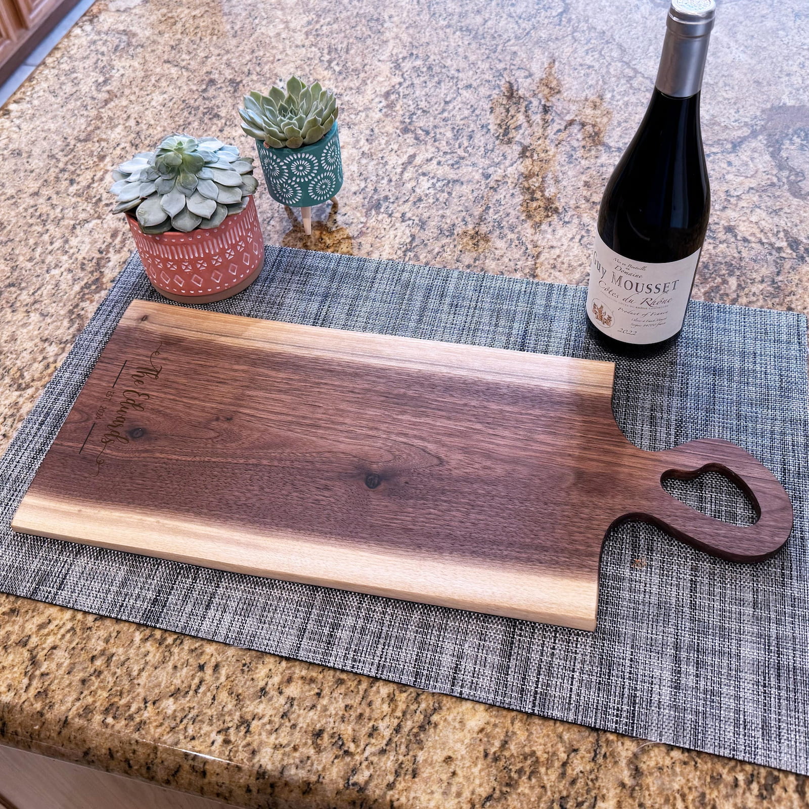 Live edge walnut charcuterie board with heart-shaped handle and wine bottle