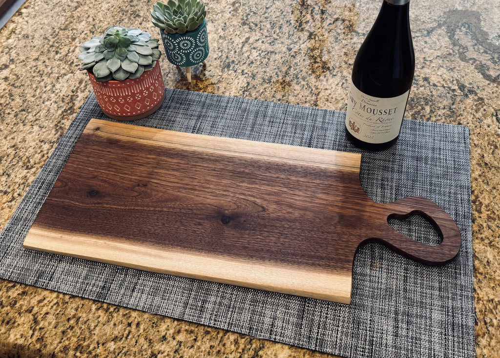 Live edge walnut charcuterie board serving platter with heart-shaped handle and wine bottle