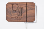 Personalized walnut cheese slicer with engraved couples monogram, names, and anniversary date on white background