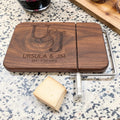 Personalized walnut cheese slicer with engraved couples monogram and anniversary date beside cheese wedge