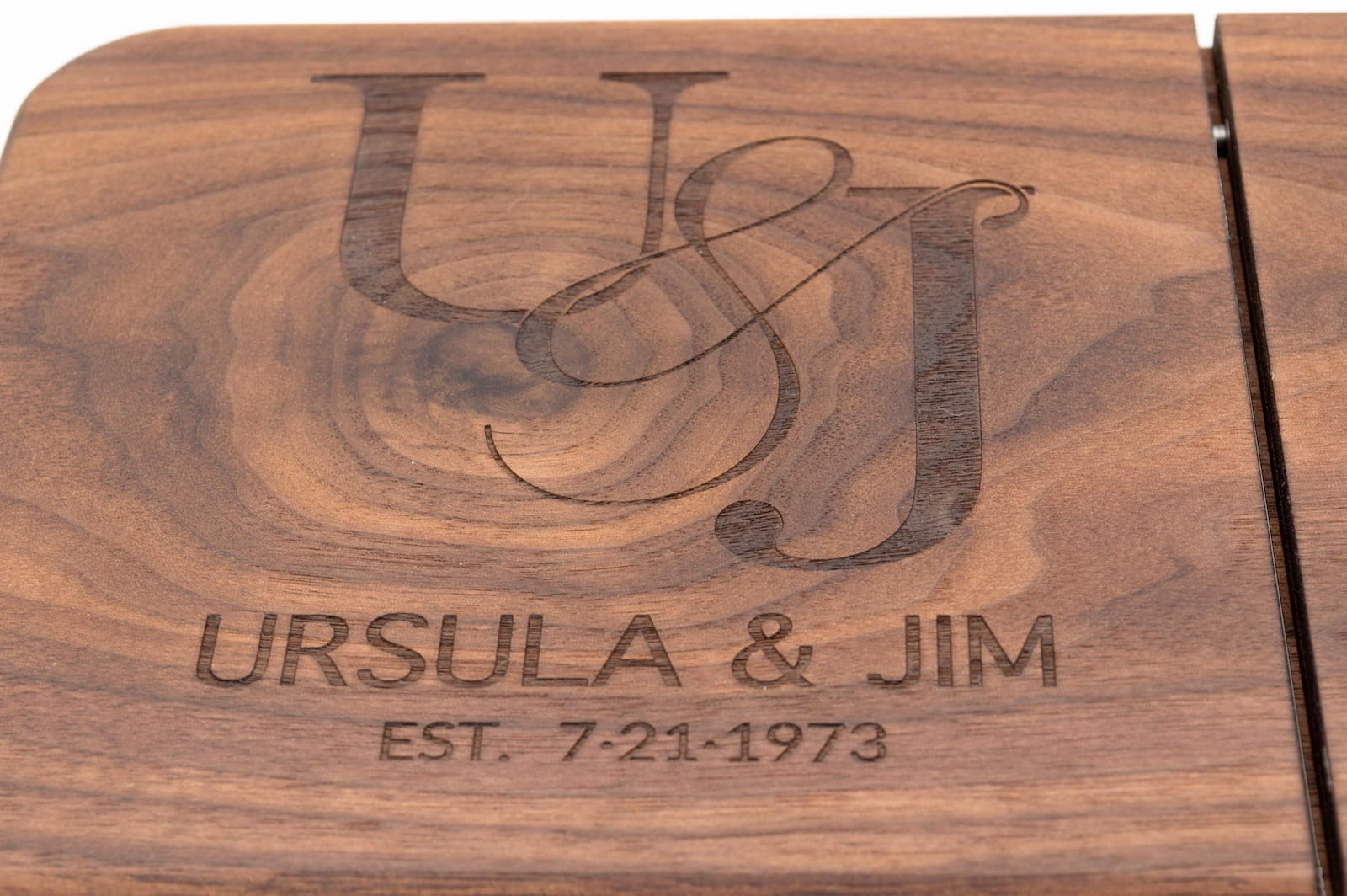 Close up of personalized walnut cheese slicer engraved with couple initials names and anniversary date