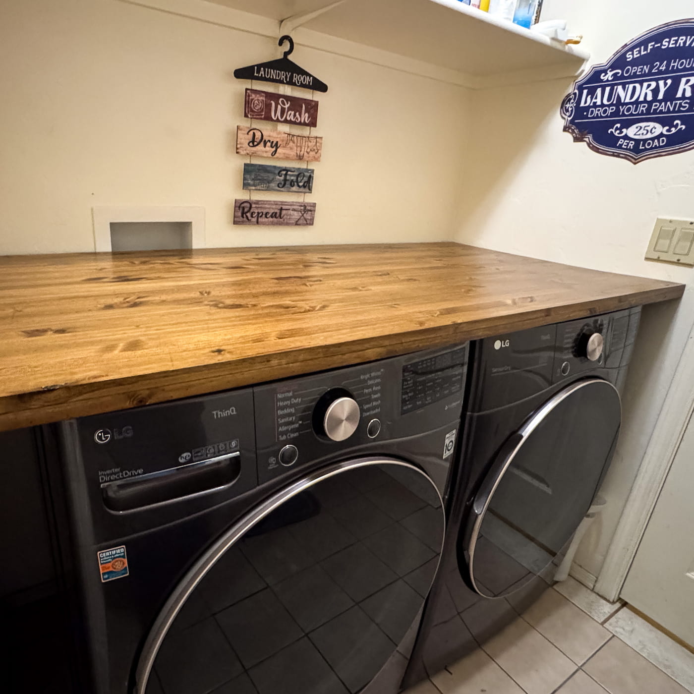 Premium oak laundry countertop installed above black front-load washer and dryer