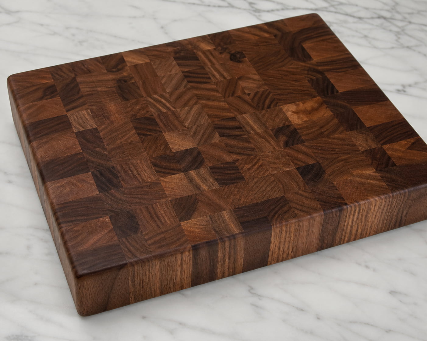 Handcrafted walnut end grain cutting board on marble countertop
