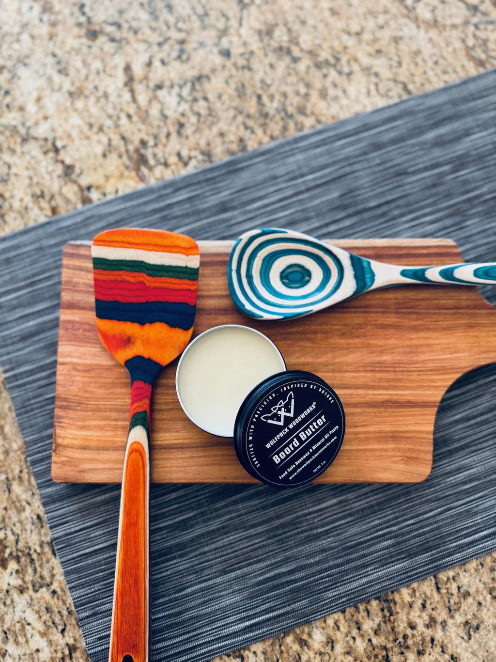 Wolfpack Woodworks board butter displayed with handmade wooden utensils on a walnut serving board